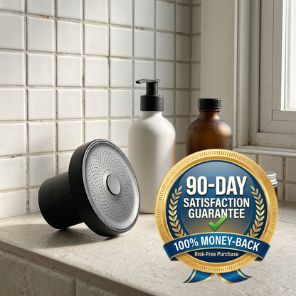 A black and silver shower head attachment shown on a bathroom counter next to a white pump bottle and an amber bottle, with a large gold and blue '90-Day Satisfaction Guarantee' badge overlaid in the foreground.